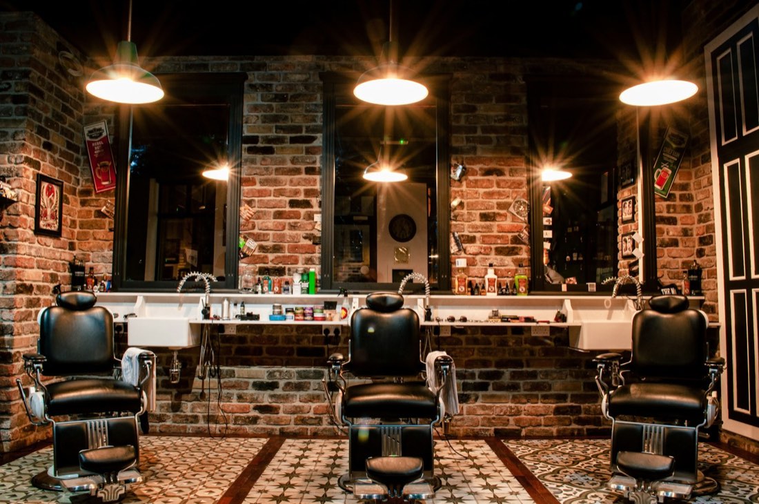 Row of vintage leather barber chairs under warm lights
