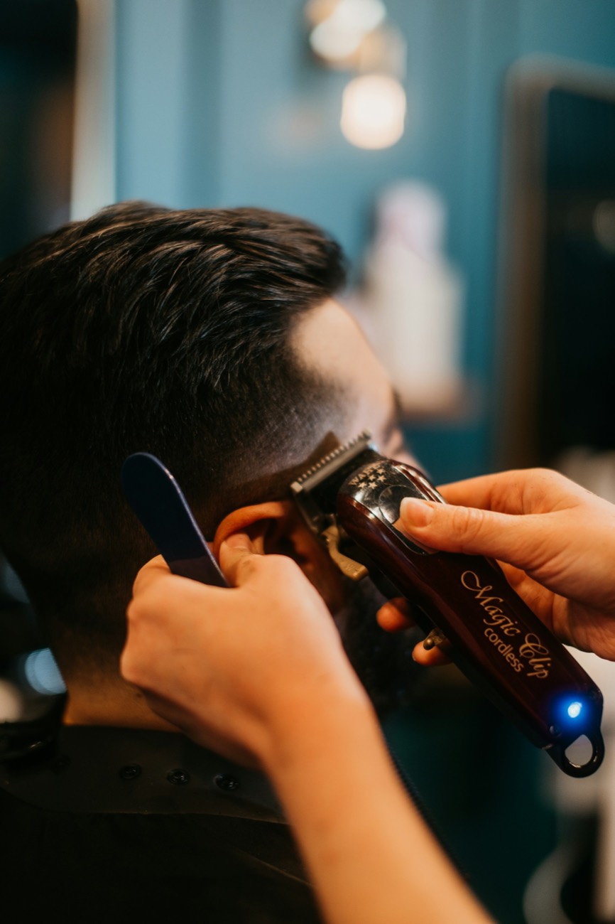 Barber blending a fade with clippers